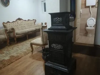 a living room with a stove and a couch at Etno selo Vile Jefimija, selo Preobrazenje, Vranje in Vranje