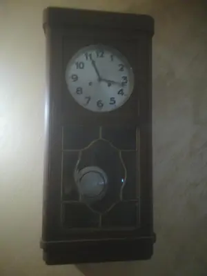 a wooden clock with a clock on the wall at Etno selo Vile Jefimija, selo Preobrazenje, Vranje in Vranje