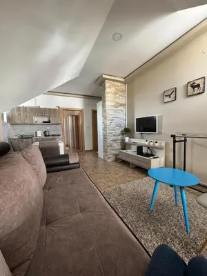 a living room with a couch and a table at Sky apartments Kopaonik in Kopaonik