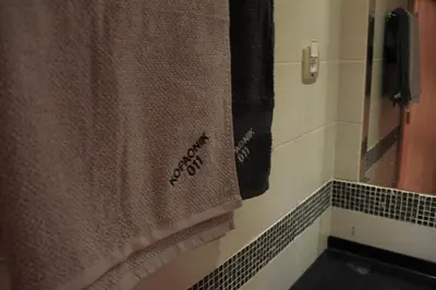 a bathroom with a towel hanging on a wall at Kopaonik011 Konaci&WoodSide Apartments in Kopaonik
