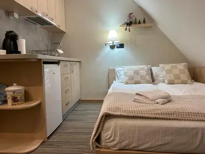 a small bedroom with a bed and a kitchen at Sweet Home Konaci in Kopaonik