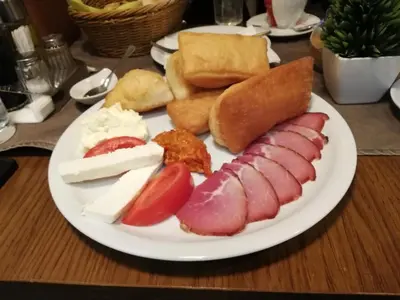 a plate of food with meats and cheese and bread at Sweet Home Konaci in Kopaonik