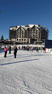 a group of people standing in the snow in front of a building at Sweet Home Konaci in Kopaonik