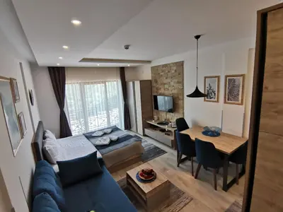 a living room with a blue couch and a table at Ski&Spa Milmari L17 in Kopaonik