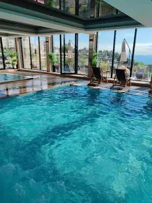 a large swimming pool with chairs in a building at Ski&Spa Milmari L17 in Kopaonik