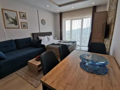 a living room with a dining table and a couch at Ski&Spa Milmari L17 in Kopaonik