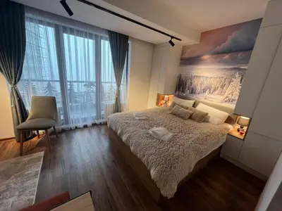 a bedroom with a bed and a painting on the wall at Apartmani TIM & SPA CENTAR in Kopaonik