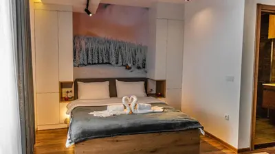 a bedroom with a bed with a painting on the wall at Apartmani TIM & SPA CENTAR in Kopaonik