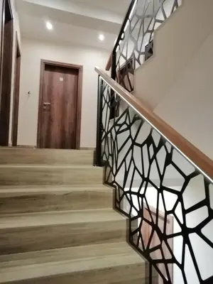 a staircase in a house with a wrought iron railing at Apartmani TIM & SPA CENTAR in Kopaonik