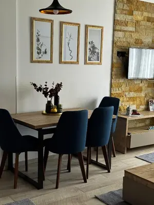 a dining room with a wooden table and blue chairs at Queen of Kop Milmari in Kopaonik