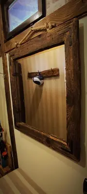 a mirror with a wooden cross on a wall at Uki & Sofi mountain house in Kopaonik