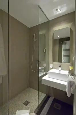 a bathroom with a sink and a glass shower at Hotel Sole in Niš