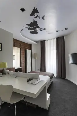 a hotel room with a bed and a desk and a television at Hotel Sole in Niš