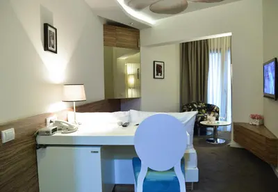 a room with a kitchen with a white counter and a table at Hotel Sole in Niš
