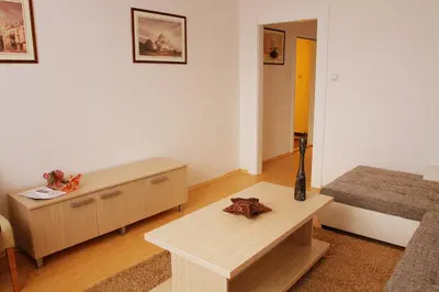 a living room with a table and a bed at Garni Hotel Hamburg in Zaječar