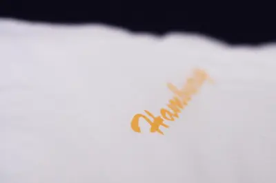a close up of a logo on a white pillow at Garni Hotel Hamburg in Zaječar
