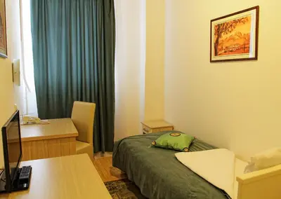 a hotel room with a bed and a desk with a computer at Garni Hotel Hamburg in Zaječar