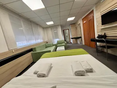 a hospital room with a large bed and chairs at Garni Hotel Consul in Niš