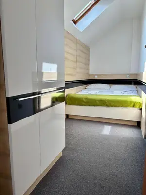 a bedroom with a bed and a white cabinet at Garni Hotel Consul in Niš