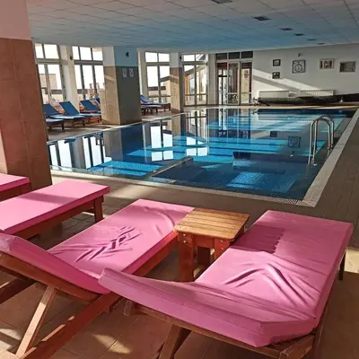 a large swimming pool with pink benches in front of it at Milmari Premier 15 in Kopaonik