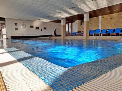 a swimming pool with blue water in a building at Milmari Premier 15 in Kopaonik