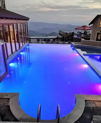a swimming pool with blue water at night at Milmari Premier 15 in Kopaonik