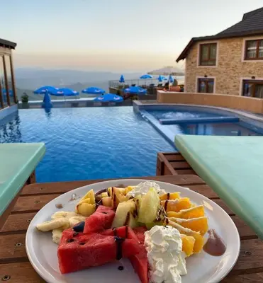 a plate of food on a table next to a pool at Milmari Premier 15 in Kopaonik