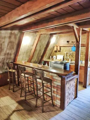 a kitchen with a bar with stools in a room at Vila Treska 98 in Kopaonik