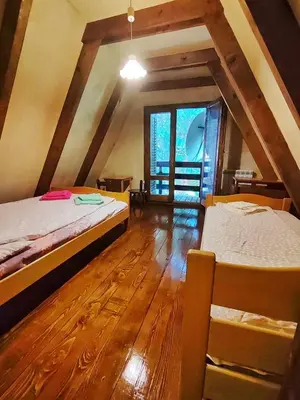 a attic room with two beds and a wooden floor at Vila Treska 98 in Kopaonik