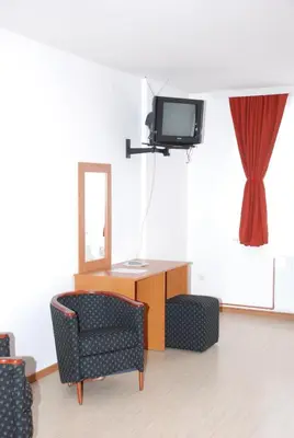 a living room with two chairs and a television at M Garni Hotel in Vranje