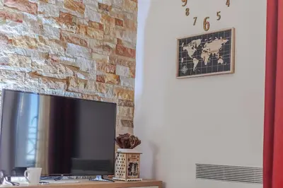 a television sitting on a table in front of a brick wall at Snow Oasis Kopaonik in Kopaonik