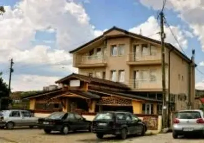 a building with cars parked in front of it at Evropa in Gračanica