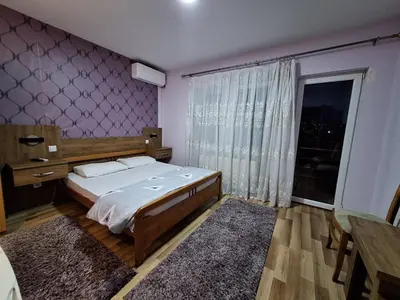a bedroom with a bed and a large window at Evropa in Gračanica
