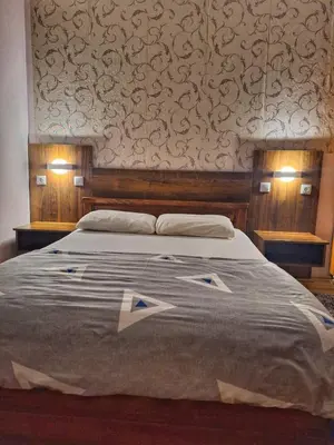 a bedroom with a large bed with a wall at Evropa in Gračanica