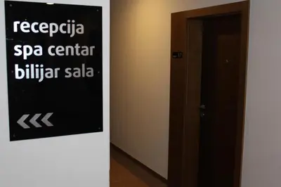 a black sign on a wall next to a door at As Lux Apartmani Kopaonik in Kopaonik