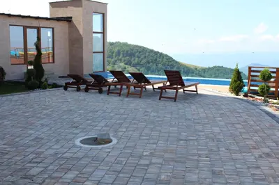 a group of chairs sitting on a patio near the water at As Lux Apartmani Kopaonik in Kopaonik