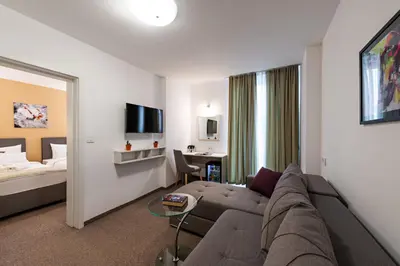 a living room with a couch and a bed at Hotel Fontana Vrnjačka Banja in Vrnjačka Banja