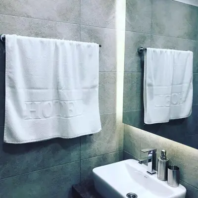 a bathroom with a sink and towels on a wall at Milmari Resort Premier 46 in Kopaonik
