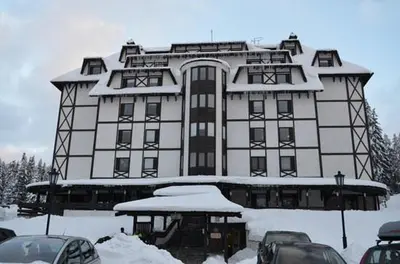 a large building with cars parked in front of it at Apartment East in Kopaonik