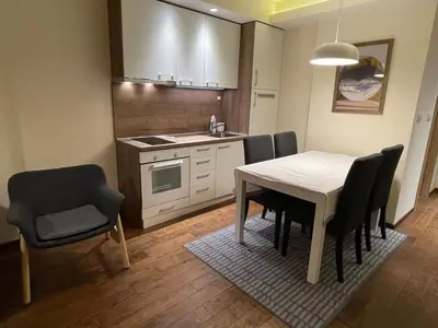 a kitchen with a dining room table and chairs at Apartment East in Kopaonik