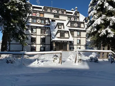 a large building covered in snow in front thereof at Apartment East in Kopaonik