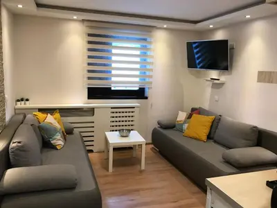a living room with two couches and a flat screen tv at YelaYeti Apartments in Kopaonik