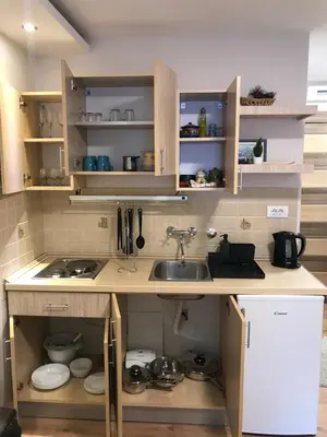 a kitchen with wooden cabinets and a sink at YelaYeti Apartments in Kopaonik