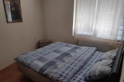 a bedroom with a bed with a blue comforter and a window at Allegro dream in Vranje
