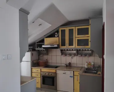 a kitchen with yellow cabinets and a white refrigerator at Allegro dream in Vranje