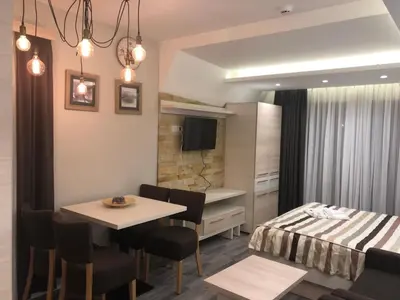 a room with a table and a bed and a bedroom at Milmari Resort in Kopaonik