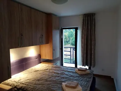 a bedroom with a bed and a large window at Kallas lux apartman in Kopaonik