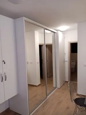 a room with a mirror and a table and chairs at Kallas lux apartman in Kopaonik