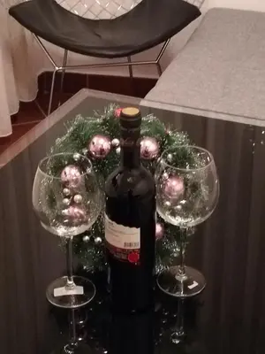 a bottle of wine and two wine glasses on a table at Kallas lux apartman in Kopaonik