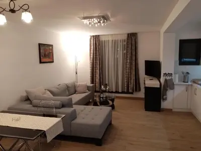 a living room with a couch and a table at Kallas lux apartman in Kopaonik